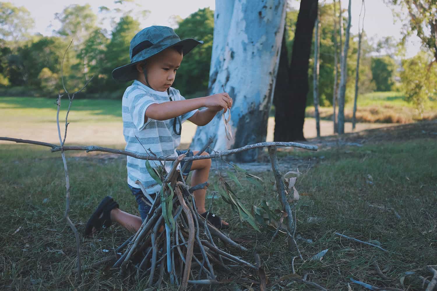Young Child Learning to Build Campfire