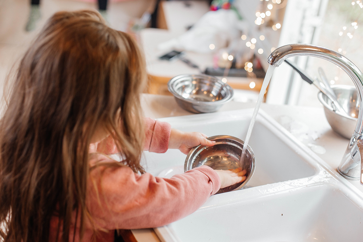 Young child washing dishes in a trailer or RV
