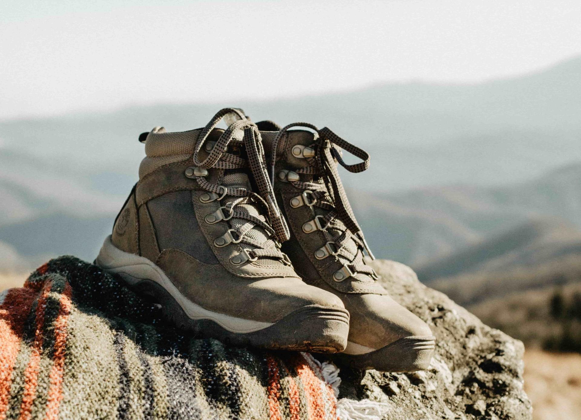 hiking boots on blanket in rocky mountains